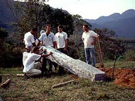 Placing stone sculpture into the ground.